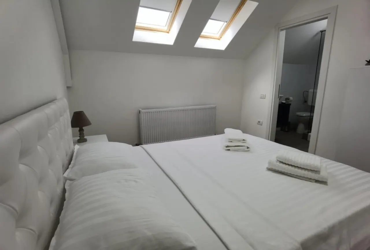 Camera de la mansardă, cu două ferestre în acoperiș deasupra patului