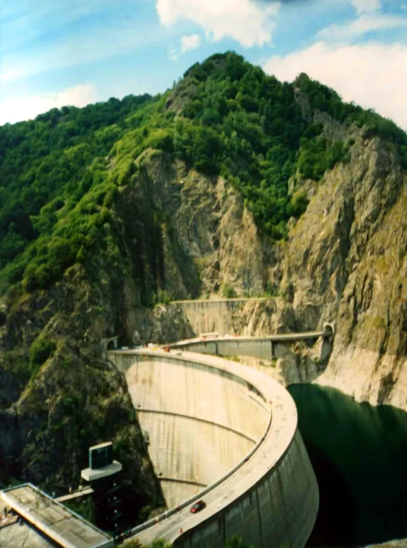 The arch of Vidraru Dam between forested mountains